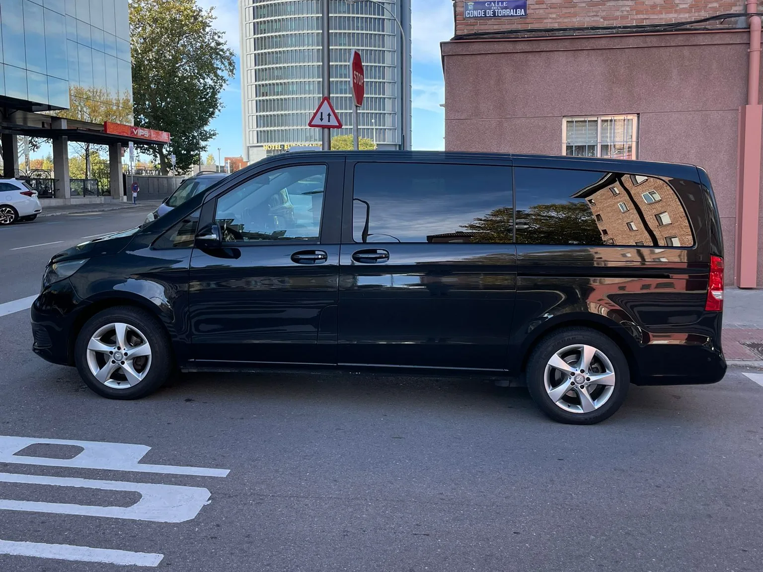 Mercedes-Benz Vito Tourer negra de perfil con las Cuatro Torres de Madrid al fondo